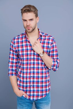 Tıraşsız yüzlü, kendine güvenen genç bir adam ve gri üzerinde izole bir saç stili..