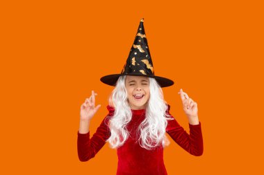 Cadılar Bayramı kostüm partisi kutlaması. Tüm Cadılar Bayramı cadıları. Cadılar Bayramı cadı kostümlü hayalperest kız. Mutlu Cadılar Bayramı rüyaları. Cadılar Bayramı kostümlü hayalperest cadı turuncu üzerinde izole edilmiş. Şaka mı şeker mi?.