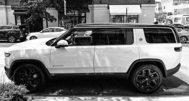 New York, ABD - 06 Ağustos 2023: Rivian R1S SUV beyaz elektrikli araç yan görüntüsü, park edilmiş.