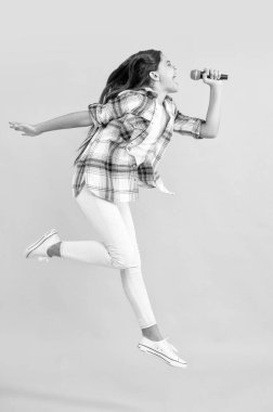 Genç kız eğleniyor. Genç müzik şarkıcısı. Müzik yaşam tarzı. Bir müzik şarkısı söyle. Genç şarkıcı mikrofon ile şarkı söylüyor. Genç kız karaokede eğleniyor. Kız mikrofonla karaoke yapıyor. çocukluk mutluluğu.