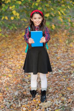 Sonbahar parkında elinde okul kitabı olan genç bir kız. Açık hava okulunda kız eğitimi. Bilgi ve eğitim. Bilgi toplama günü. Sonbahar Tutma Kitabı 'ndaki kız. Eğitim kitabı. Okula geri dön..