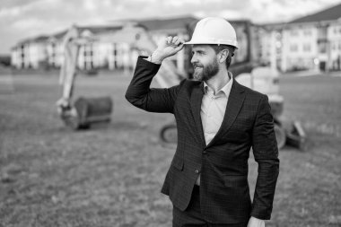 Şantiyedeki neşeli inşaat işyeri sahibi. İnşaat işyeri sahibi dışarıda. İnşaat işletmesi sahibinin fotografı. Takım elbiseli inşaat işyeri sahibi.