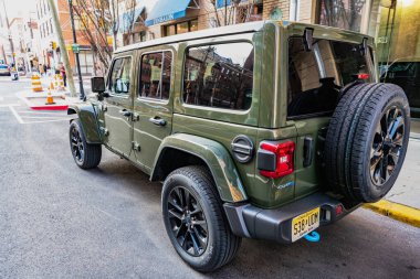New York, ABD - 15 Mart 2024 Jeep Wrangler 4xe Sahara SUV arabası. Jeep Wrangler caddeye park etmiş. Jeep Wrangler 'ın SUV arabası. Jeep Wrangler Sahra, nadir bir manzara..