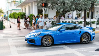 Miami Beach, Florida USA - 6 Haziran 2024: Porsche 911 Turbo S Miami Beach Ocean Drive 'da. Miami 'de mavi Porsche 911 Turbo S. yan görünüm
