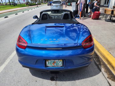 Miami Beach, Florida USA - 8 Haziran 2024: 2018 Porsche 718 Boxter mavisi Miami sahilinde. Ocean 'daki lüks araba porshche' si Miami plajına gidiyor. arka plan