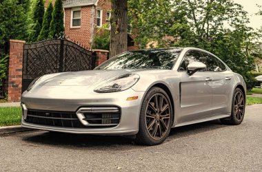 New York City, USA - August 26, 2023: Porsche Panamera sportscar car silver color parked, front corner view. clipart