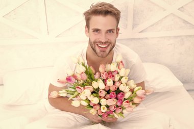 Mart laleleri açan mutlu romantik adam. 8 Mart için laleli romantik bir adam. Mart laleli romantik bir adamın fotoğrafı. Mart laleli romantik bir adam..