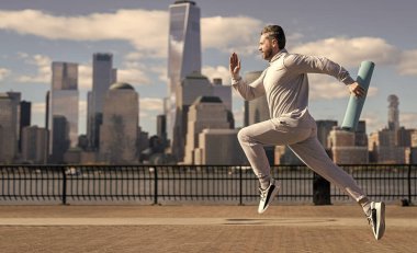 Manhattan 'da koşan adam. New York 'ta sabah sporu koşucusu. Spor antrenmanında koşan koşucu. Sporcu koşucu ya da koşucu. Spor takım elbiseli bir adam koşu yapıyor. Reklam..
