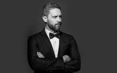 Formalite icabı giyinen bir adamın fotoğrafı. Adam resmi smokin giyer. Formalite icabı smokinli adam kırmızı arka planda izole edilmiş. Stüdyoda resmi kıyafet.