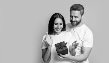 İlanlı bir çiftin fotoğrafı. Kadınlar Günü 'nde. Sarı arka planda yaşayan sürpriz çift. Stüdyoda sürpriz hediyeleri olan çift. Sürpriz hediye kutusu olan tatil çifti.