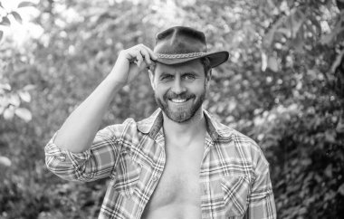 Kovboy şapkalı mutlu batı adamı. Kareli gömlekli batı kovboyu. Batı kovboyu batı şapkası giyiyor.