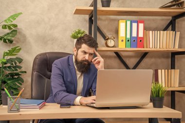 Bir proje yürütüyorum. İşletme. İşyerinde düşünceli bir yönetici. Dizüstü bilgisayarda çalışan profesyonel bir adam. Ofis işi.