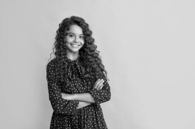 Sarı arka planda uzun sarı kıvırcık saçlı mutlu çocuk..