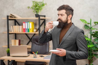 İş adamı kılığındaki acımasız CEO ofiste sabah kahvesinin tadını çıkarıyor..