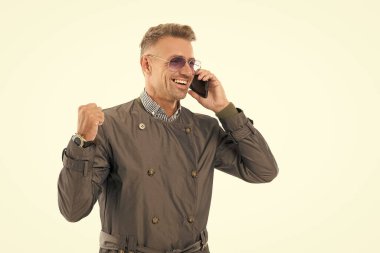 Mutlu gülümseyen başarılı iş adamı iş adamı yönetici cep telefonuyla konuşuyor. Resmi palto stüdyosunda kazanan jest yapıyor..
