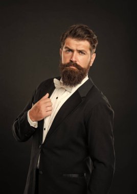 bearded businessman in tuxedo on black background, boss.