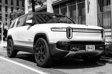 New York, ABD - 06 Ağustos 2023: Rivian R1S SUV önden ve yolcu tarafından elektrikli beyaz araç görüntüsü, park edilmiş