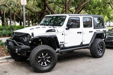Miami Beach, Florida USA - 10 Haziran 2018 Jeep Wrangler Sınırsız Sahara 4x4 beyaz okyanus sürücüsü Miami plajı. Jeep yaygın bir arazi aracı markasıdır. Yan görünüş. beyaz.