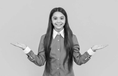 Ürün sunmak ve sunmak. Üniformalı genç kız reklam yapıyor. Genç kız ürünleri fotokopi alanıyla sunuyor. Reklam seçen bir kız. Genç öğrencinin neşeli bir yüzü var..