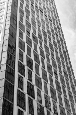 Gökdelen mimarisi. Camsı yüzlü bir gökdelen. Modern şehir binası. Metropolis City 'de bir gökdelen. Şehir merkezinde gökdelenli bir şehir. Ofis binası dış tarafı.