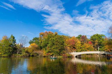 New York City, ABD - 25 Ekim 2023: sonbahar doğası. Gölde teknesi olan Central Park. Sonbahar manzarası. Central Park 'ta kürek çeken insanlar. Central Park 'ta sonbahar ağaçları, Manhattan.