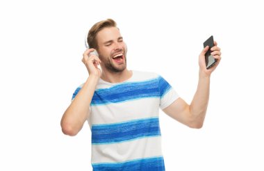 Z jenerasyonundaki adam eğitim ya da müzik için telefon uygulaması kullanıyor. Beyazda izole edilmiş kablosuz kulaklıklı modern telefon. Milenyum adamı müzik dinliyor ve şarkı söylüyor. Telefon kullanan kulaklıklı bir adam..