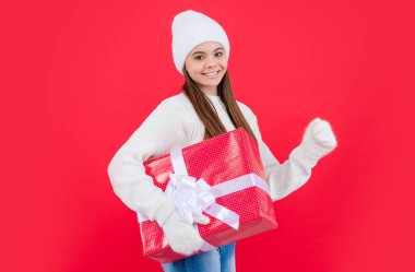 Yeni yıl tatili. Stüdyoda yeni yıl hediyeli mutlu genç kız. Genç kızlar yeni yıl hediyelerini kırmızı arka planda saklarlar..