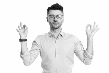 Beyaz arka planda meditasyon yapan bir iş adamı. Stüdyoda meditasyon yapan iş adamı. Meditasyon yapan bir iş adamının jesti. Yetişkin iş adamı iyi niyetle meditasyon yapıyor..