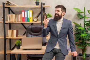 İş için yüz yüze görüşecektik. Mutlu patronun ofiste görüntülü görüşmesi var. Akıllı telefondan görüntülü arama yapıyorum. Mobil iletişim.