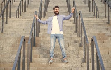 Gülümseyen hippi aşağıda. Sakallı bir hippi. Merdivenlerde hippi bir adam var..