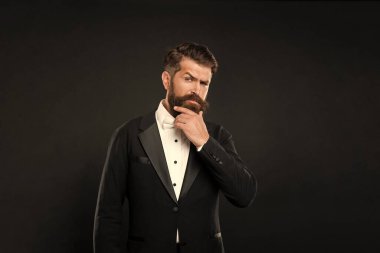 Smokin papyonlu lüks bir adam. Siyah arka planda resmi giyinmiş bir beyefendi. erkek resmi moda.