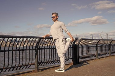 Spor adamı antrenman için ısınıyor. New York 'ta sporcunun esneme hareketleri. Sporcu koştuktan sonra kaslarını esnetiyor. Sporcu esnekliği artırmak için esneme hareketi yapar. Esneklik eğitimi.