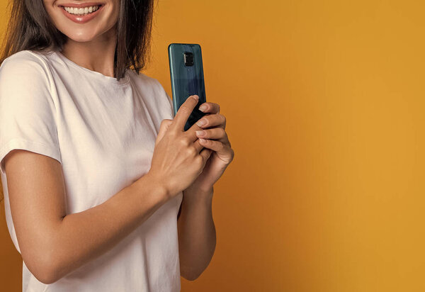 Женщина прячет телефон, обрезанный вид. Женщина со смартфоном. Болтали и переписывались. Подключен онлайн. Личное сообщение. SMS-сообщение. Девушки в чате онлайн. Копирование пространства.