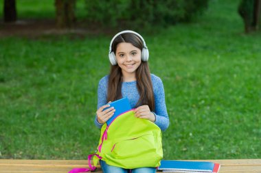 Okula dönelim. Eğitim ve bilgi. Kitapla sesli kitap dinleyen kız. Audiobook ödevi. Öğrenci kız. Okul eğitimi. Öğrenci hayatı. Liseli kız dışarıda kulaklıkla müzik dinliyor..