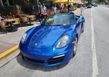 Miami Beach, Florida USA - 8 Haziran 2024: 2018 Porsche 718 Boxter mavisi Miami sahilinde. Ocean 'daki lüks araba porshche Miami plajına gidiyor..