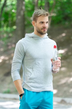 Günde bir içki. Sıvı yeterliliği. Susuz kalma. Susamış sporcu. Adam maden suyu tutuyor. Susadım. Plastik şişeli genç bir adam. Sağlıklı bir yaşam tarzı. Vücutta su dengesi. Boğazım kurudu..