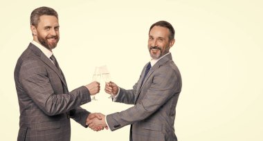 İş anlaşmasında başarılı bir anlaşma. Beyazlar üzerinde izole iş adamları. Ortaklık kavramı. İş anlaşmasını kutlamak için. Şampanyayla anlaşma yaptıktan sonra el sıkışan iki işadamı. Boşluğu kopyala.