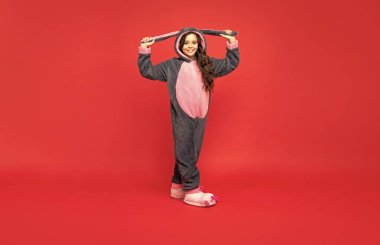 Rahat bir uyku giysisi içinde neşeli bir çocuk. Tatlı rüyalar. Rahat bir pijama ya da bornoz. Genç kız kendini rahat hissediyor. çocukluk mutluluğu. Günaydın. Çocuk yumuşak bir gece elbisesi giyiyor. tam uzunluk.