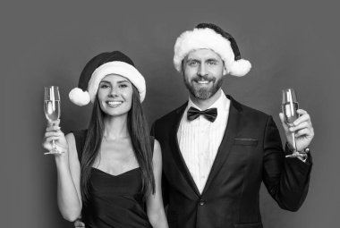 Mutlu Noel Baba çifti için kurumsal Noel partisi. Stüdyodaki Noel Baba çifte mutlu Noeller. Noel Baba çifti için Noel kutlaması. Noel Baba şapkalı çift şampanyayı kırmızıda izole ediyor..