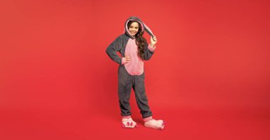 childhood happiness. good morning. kid wear soft night suit. full length. glad child in cozy sleepwear. sweet dreams. comfortable pajama or home bathrobe. teen girl feeling relaxed.