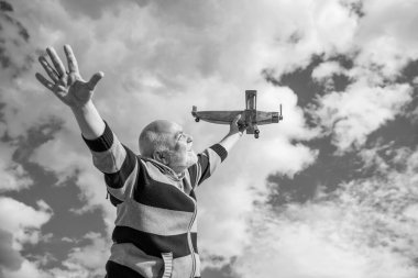 Mutlu emeklilik. Yaşlı büyükbaba ve oyuncak. Emekli yaşlı adam dışarıda. Emekli olan yaşlı adam gökyüzü geçmişinde.