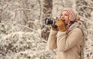 Büyüleyici solgunluğun ve dondurucu kış atmosferinin tadını çıkar. Kış hobisi. Çarpıcı kış fotoğrafları çekiyor. Fotoğraflarla kar manzarasının güzelliğinin tadını çıkar. Profesyonel kameralı kadın fotoğrafçı.