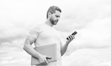 Bilgisayarlı bir adam gökyüzünde akıllı telefondan sohbet ediyor..