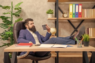 Takım elbiseli yorgun bir adam ofiste kahve molası sırasında bacaklarıyla dinleniyor, dinleniyor..