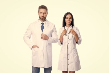 Stüdyoda iki kardiyolog ve hemşire var. Kardiyolog ve hemşirenin fotoğrafı beyaz önlük giyiyor. Doktor kardiyolog ve steteskoplu hemşire. Kardiyolog doktor ve hemşire beyazla izole edilmiş..