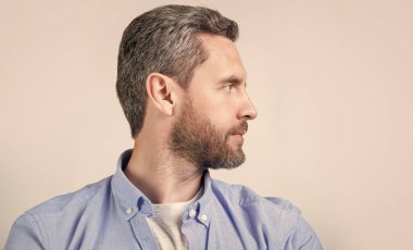 Stüdyoda sakallı sıradan bir beyaz adam profili. Kafkasyalı bir adamın resmi sıradan giyiniyor. Gündelik tişört giyen beyaz bir adam. Gri arka planda izole edilmiş günlük tarzda beyaz bir adam..