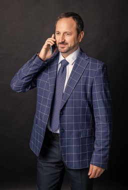 Akıllı telefondan konuşan iş adamı siyah arka planda izole edilmiş. Stüdyoda akıllı telefondan konuşan bir iş adamı. Akıllı telefondan konuşan bir iş adamı. Akıllı telefondan konuşan iş adamının fotoğrafı.