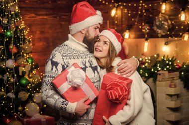 Sevgi dolu bir çift Noel ağacı arka planına sarılır. Romantik duygular. Kış aşkı. Bir tanem için sürpriz. Birbirine aşık çiftler Noel kutlamalarının tadını çıkarırlar. Aile geleneği. Noel zamanı.