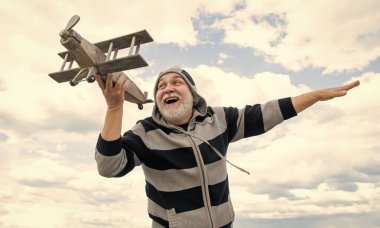 Emekli kıdemli bir adam. Emekli olmuş olgun bir adam. Gökyüzündeki yaşlı adam oyuncak uçağıyla dışarıda.