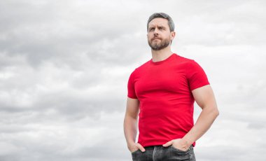 man in red shirt outdoor on sky background. copy space.
